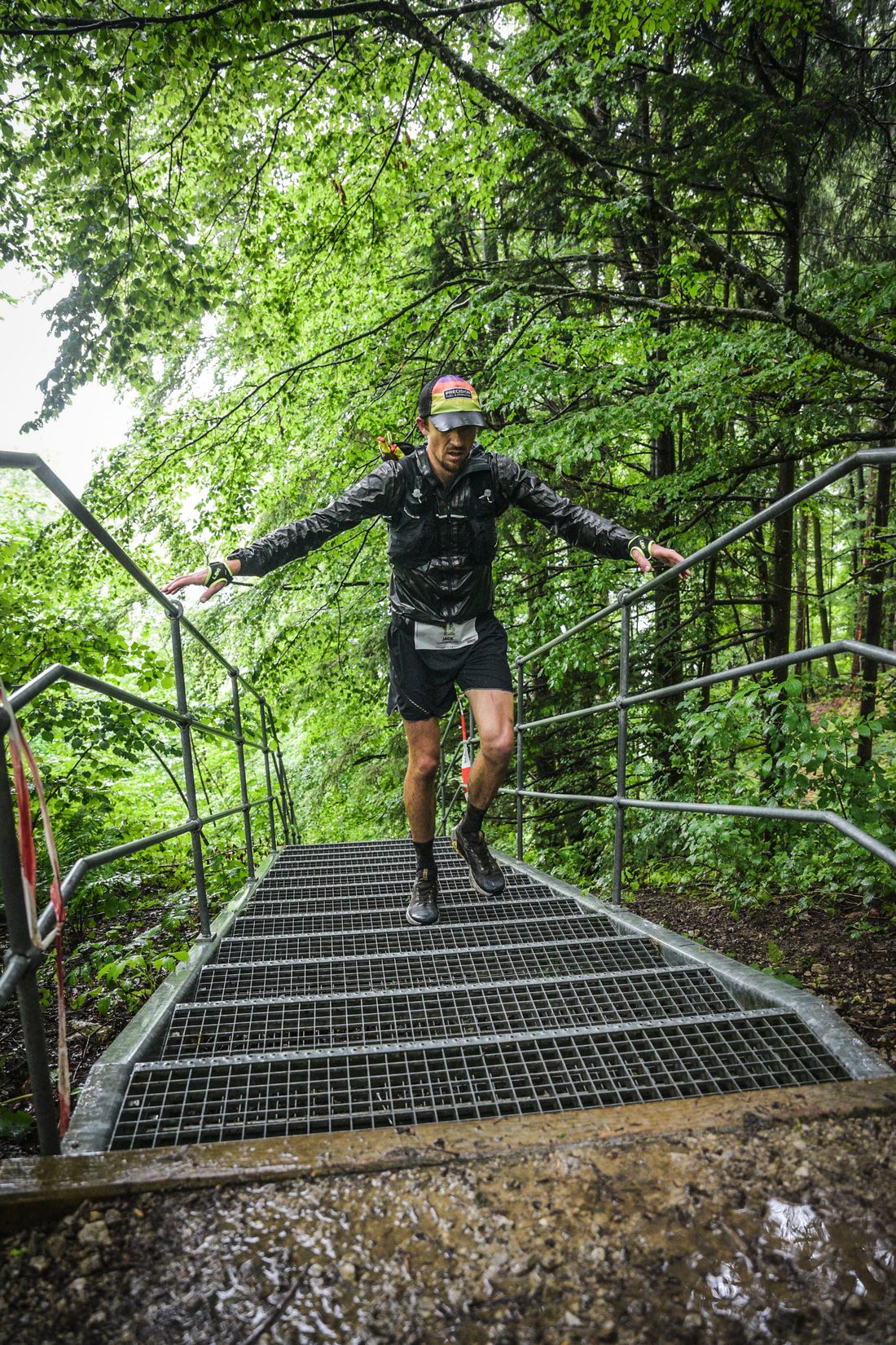 Jack Chamberlain springt beim Mozart 100 by UTMB im Regen eine Treppe hinunter.