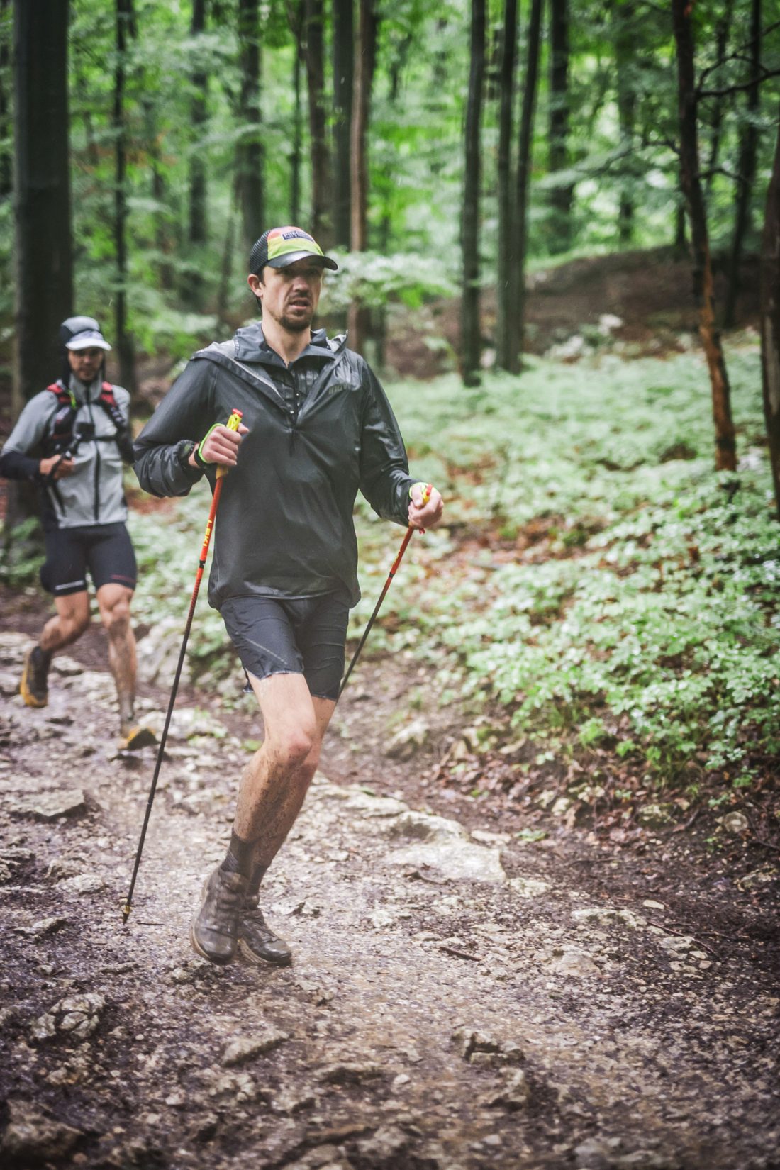 Jack Chamberlain läuft beim Mozart 100 by UTMB im Regen einen steilen Waldpfad hinauf.