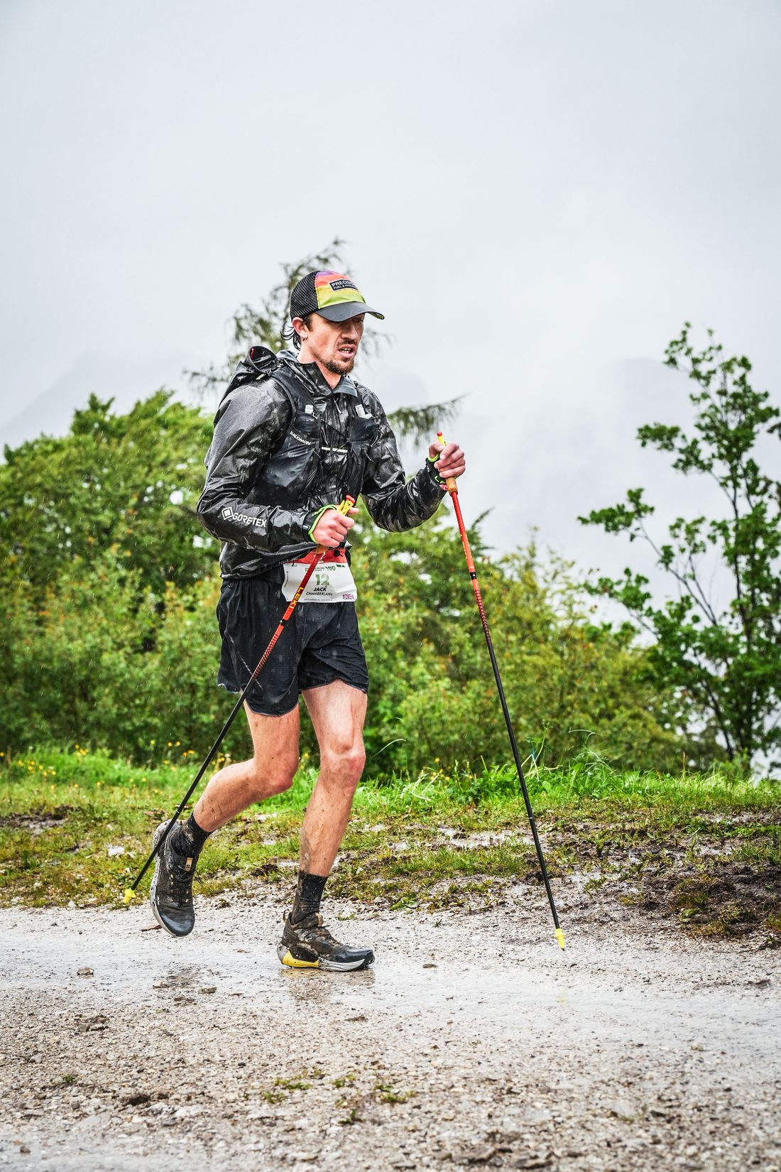 Jack Chamberlain läuft beim Mozart 100 by UTMB im Regen über einen nassen Pfad.