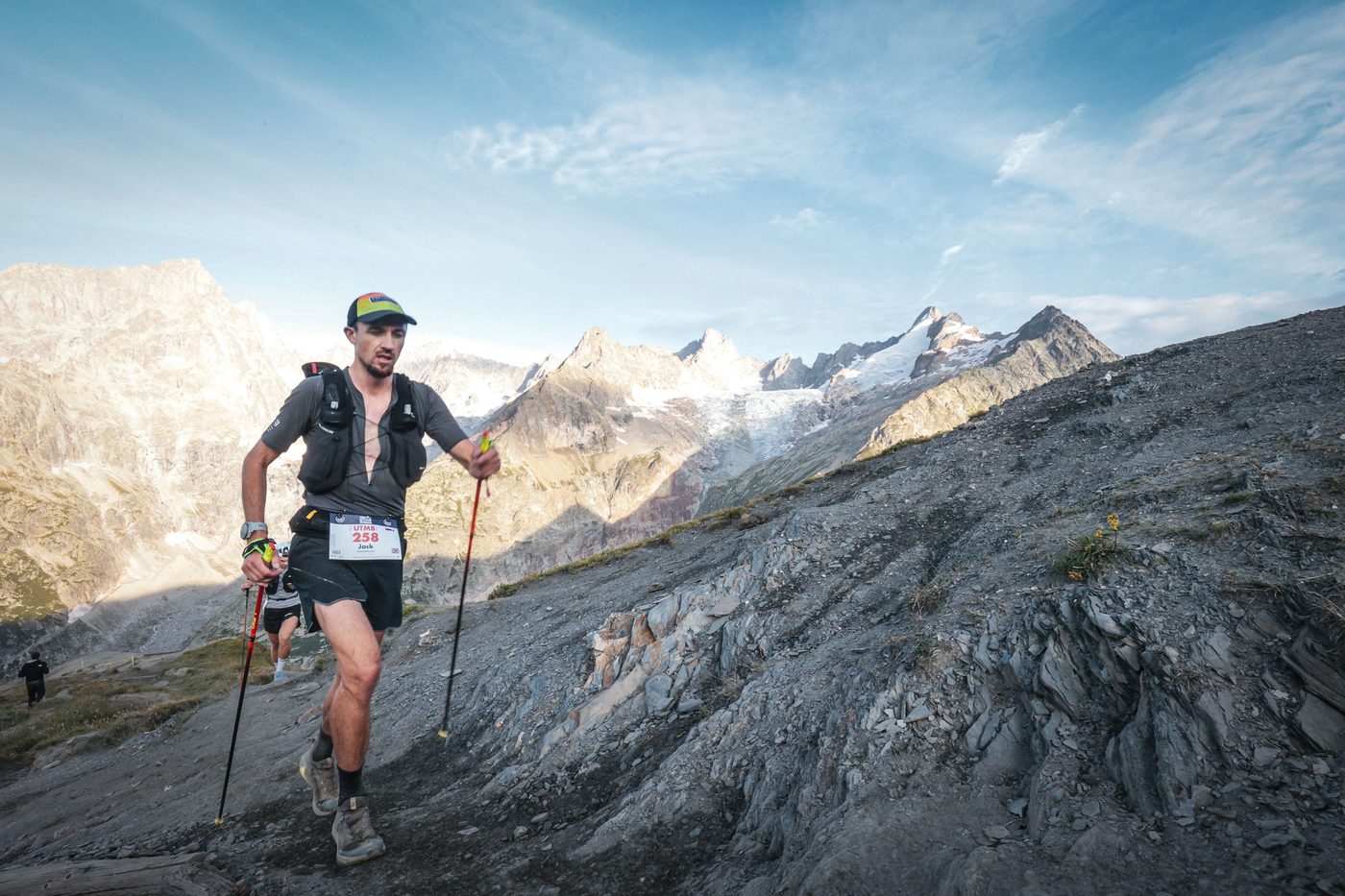 Jack Chamberlain steigt bei der UTMB Mont-Blanc mit Stöcken eine Gletschermoräne hinauf.